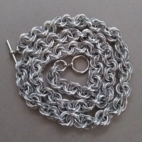 Bright silver aluminum chain mail bracelet on a grey background.