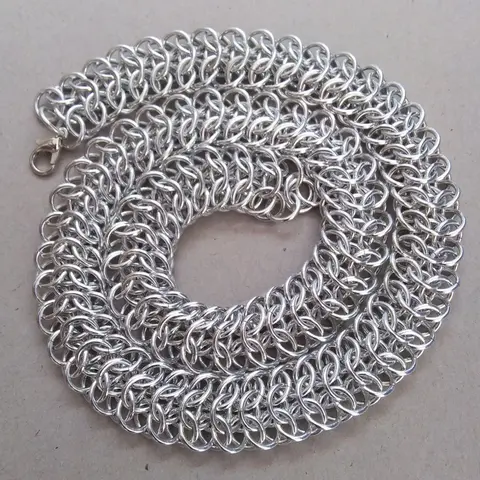 Bright silver aluminum chain mail necklace on a grey background.