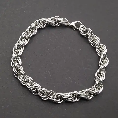 Bright silver aluminum chain mail bracelet on a dark grey background.