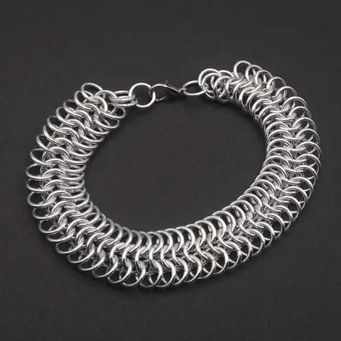 Bright silver aluminum chain mail bracelet on a dark grey background.