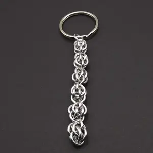 Bright silver aluminum chain mail keychain on a dark grey background.