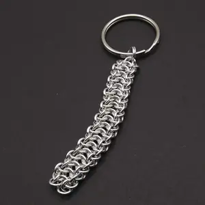 Bright silver aluminum chain mail keychain on a dark grey background.